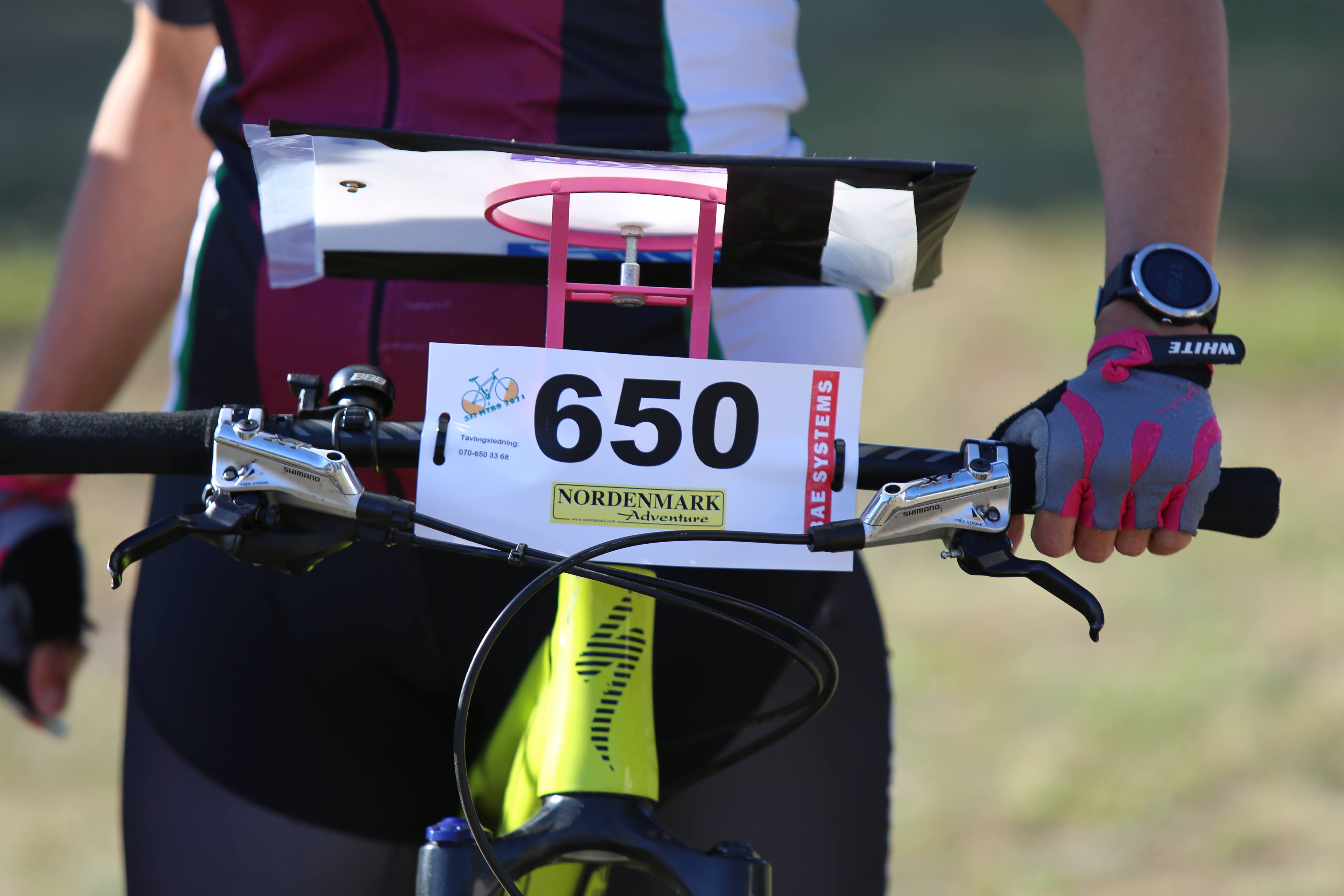 Mountainbikeorienterare närbild med kartställ och nummerlapp